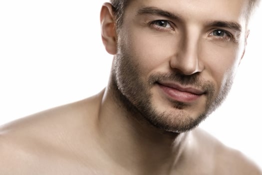 Young and handsome man with smooth skin on white background photo