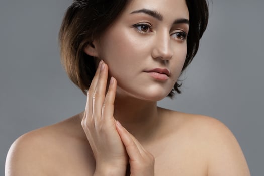 Young beautiful brunette woman on gray background photo