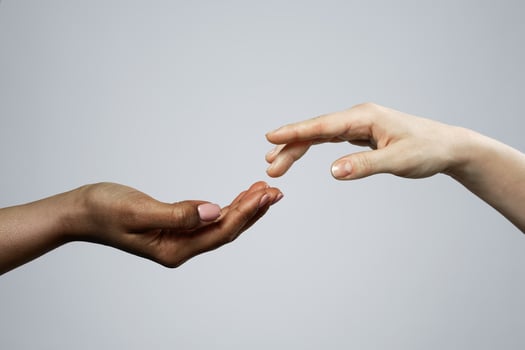 African and Caucasian female hands on gray background photo