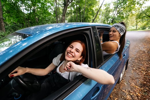 Two girlfriends fool around and laughing together in a car photo