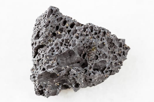 rough black Pumice rock on white marble photo
