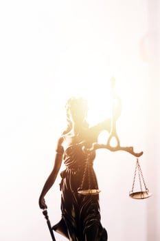 Justice and law concept.Male judge in a courtroom with the gavel, working with, computer and docking keyboard, eyeglasses, on table in morning light photo
