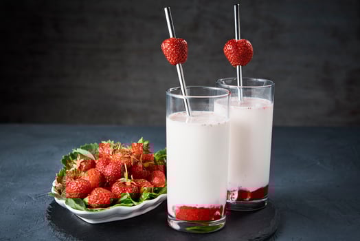 Strawberry milk smoothie in glass with straw on a dark background photo