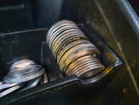 Some rupiah coins and one hundred thousand rupiah notes and some other money in a box provided on the dashboard of the car photo