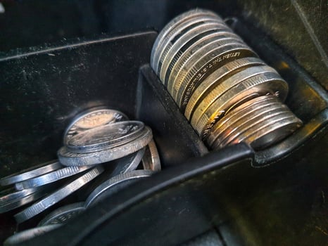 Some rupiah coins and one hundred thousand rupiah notes and some other money in a box provided on the dashboard of the car photo