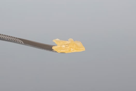 cannabis resin wax and dab tool for smoking close up on gray background photo