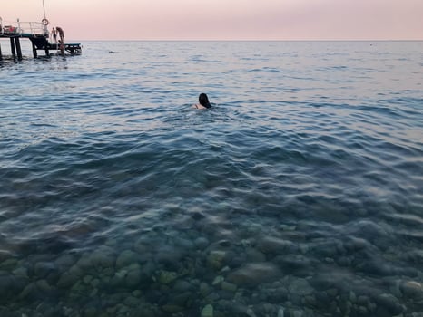 Girl swims in the sea, back view photo