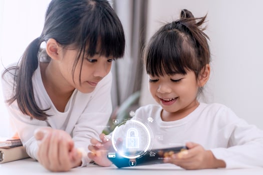 Child safety online. Little girl using smartphone at home. icon of internet blocking app on foreground photo