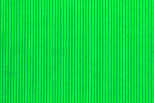 Abstract paper green geometric symmetrical texture striped surface vertical lines background. Structure design cardboard shape backdrop. Holiday spring decoration interior concept. Flatlay, close-up photo