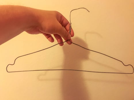 homemade wire hanger for clothes. clumsy, uneven hanger with your own hands. storing clothes in a poor man's wardrobe photo