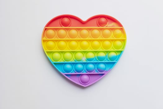Pop it fidget toy. Multi-colored anti-stress toy with a wing shape on a white background photo