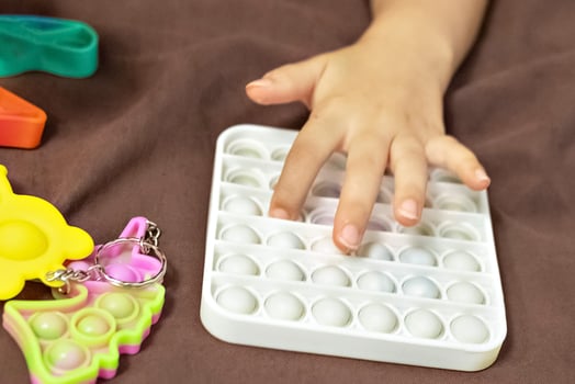 Pop it is a multi-colored anti-stress toy in children's hands. Bubble game. Antistress toys. photo