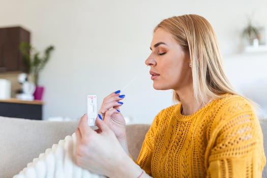 Young woman holding self testing self-administrated swab and medical tube for Coronavirus covid-19, before being self tested at home photo