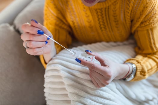 woman using cotton swab while doing coronavirus PCR test at home. Woman using coronavirus rapid diagnostic test. Young woman at home using a nasal swab for COVID-19. photo