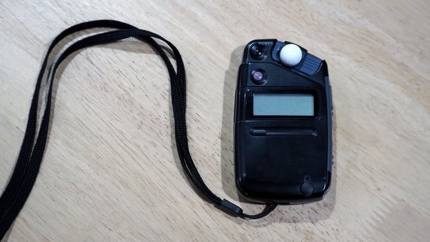 Light meter black color on the wood texture table and top view angle. photo