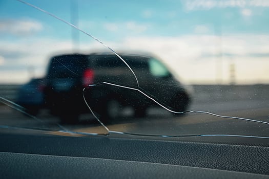 View through cracked glass on the road, stone smashed car windshield photo