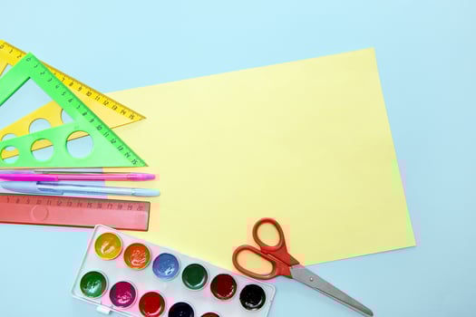 empty yellow sheet framed with school accessories with copy space, back to school, school background photo