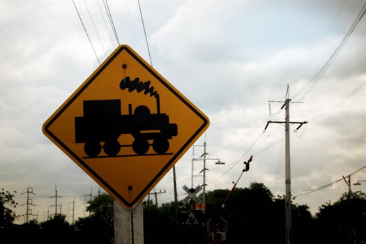 Traffic sign, watch out for the train. Drive slowly and watch out for the way ahead. There is a train passing by on rural roads of Thailand and the beautiful blue sky in the countryside. photo