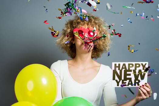 Beautiful woman celebrating New Year with confetti and holding sign. photo