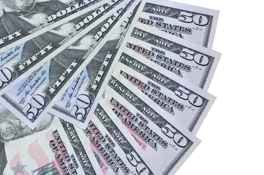 50 US dollars bills lies isolated on white background with copy space stacked in fan shape close up photo