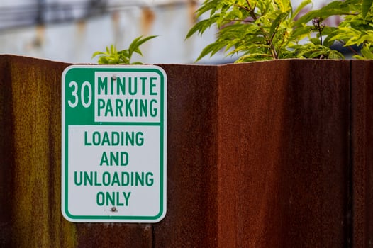 Old faded worn metal 30 minute parking sign with green text photo