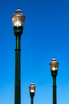Glass street lamp head on a cast iron post photo