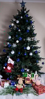 Christmas, New Year interior with red brick wall background, decorated fir tree with garlands and balls, dark drawer photo