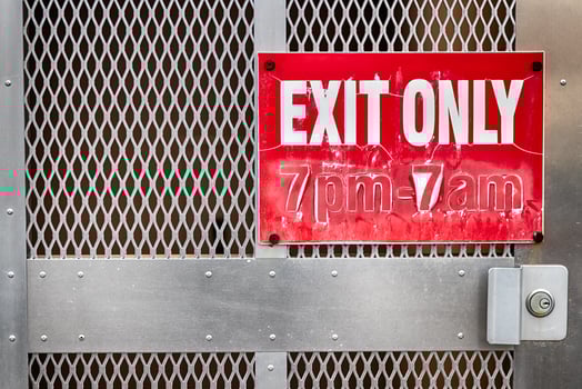 Faded worn exit only sign on a steel gate photo