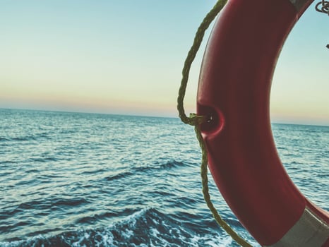orange life buoy on the ship. cruise. half circle. rescue equipment under an awning against the background of the sea photo