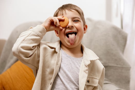 Portrait of little adorable boy holding biscuit. Kid with cookie. Child and gluten. Healthcare, gluten intolerance by kids. Preschool child with casual clothing. Smile, positive emotions. photo