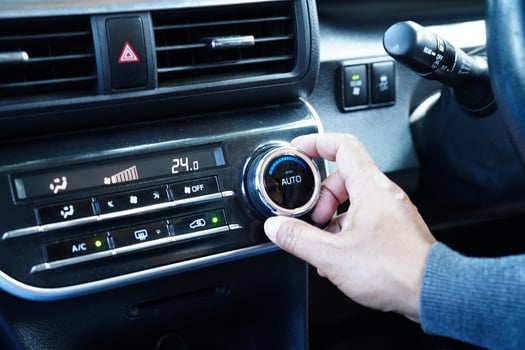 Asian woman driver tuning temperature control air condition system in car. photo