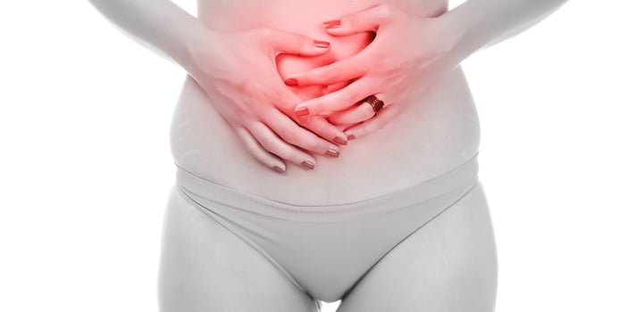 Young woman suffering from strong abdominal pain. isolated on white background photo