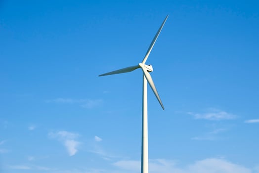 Wind turbine against blue sky. Wind power energy concept photo