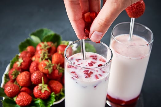 Strawberry milk smoothie in glass with straw on a dark background photo