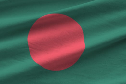 Bangladesh flag with big folds waving close up under the studio light indoors. The official symbols and colors in banner photo