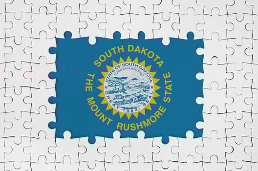 South Dakota US state flag in frame of white puzzle pieces with missing central part photo