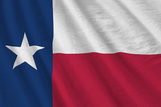 Texas US state flag with big folds waving close up under the studio light indoors. The official symbols and colors in banner photo