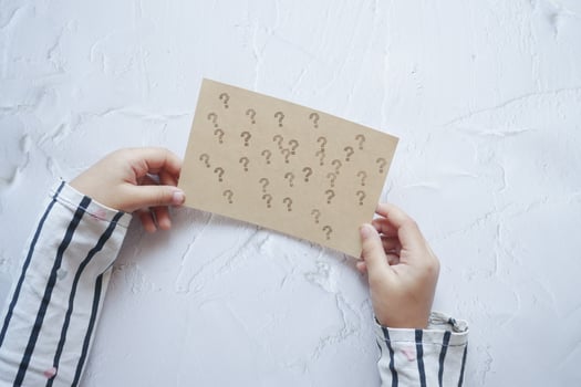 child holding a question mark paper on white background photo