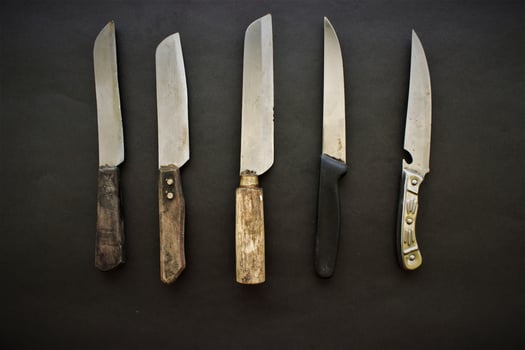 Many knifes lie on black background for cooking photo