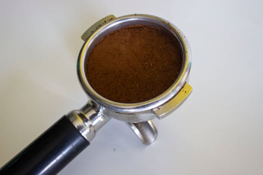 porta filter with ground coffee and coffee bean isolated from a white background photo