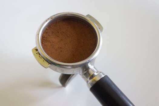 porta filter with ground coffee and coffee bean isolated from a white background photo