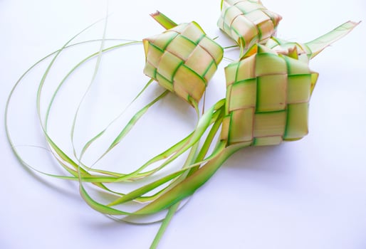 ketupat in earthenware plate isolated on white background. Ketupat ,Rice Dumpling is food served when idhul fitri eid mubarak in Indonesia, made from rice wrapped in young coconut leaves, janur photo