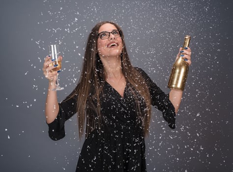 Beautiful woman celebrating New Year with confetti and champagne photo