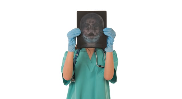 Young female doctor looking at the x-ray picture. isolated on white photo