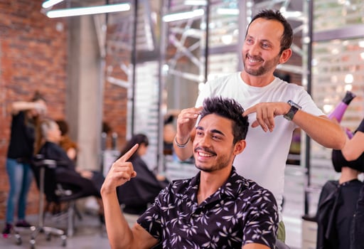 Professional hairdresser is cutting men's hair in beauty salon. photo