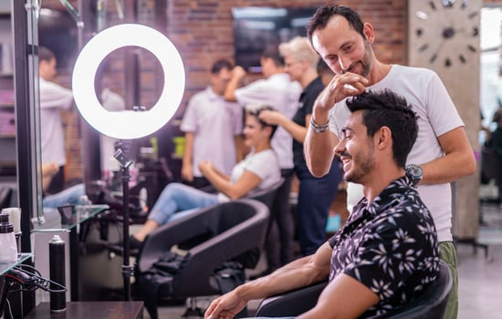 Professional hairdresser is cutting men's hair in beauty salon. photo