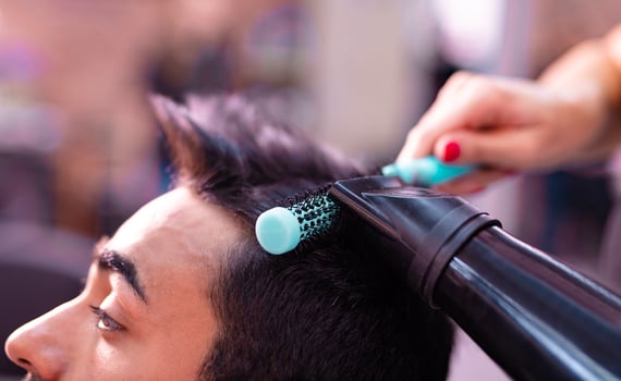 Professional hairdresser is cutting men's hair in beauty salon. photo