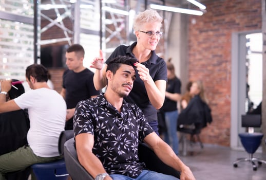 Professional hairdresser is cutting men's hair in beauty salon. photo