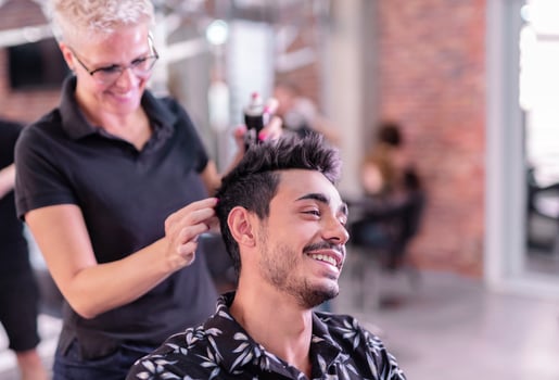 Professional hairdresser is cutting men's hair in beauty salon. photo