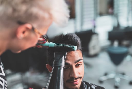 Professional hairdresser is cutting men's hair in beauty salon. photo